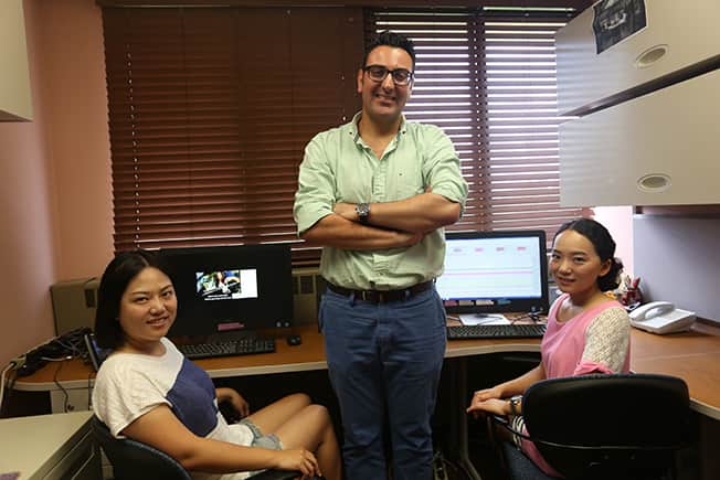 Photo of two students with professor in the lab